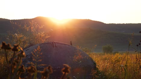 Albania,-concrete-bunker-amidst-mountains,-against-the-backdrop-of-the-rising-sun