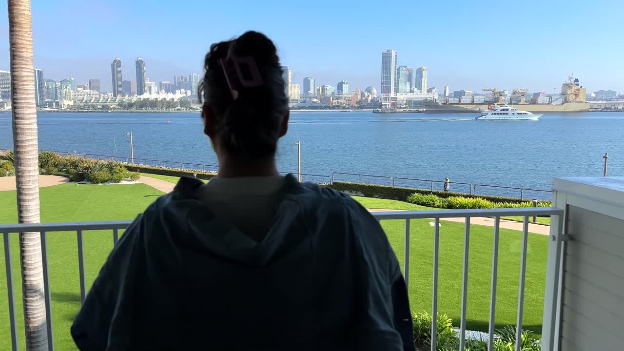 una mujer de pie en un balcón con vistas a la bahía de coronado en san diego, california