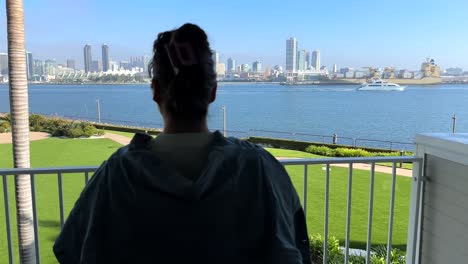 woman standing on a balcony overlooking coronado bay in san diego, california