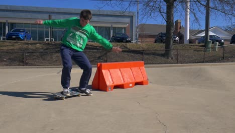 El-Patinador-Hace-Un-Truco-De-Patineta-Sobre-Una-Barrera-Naranja.