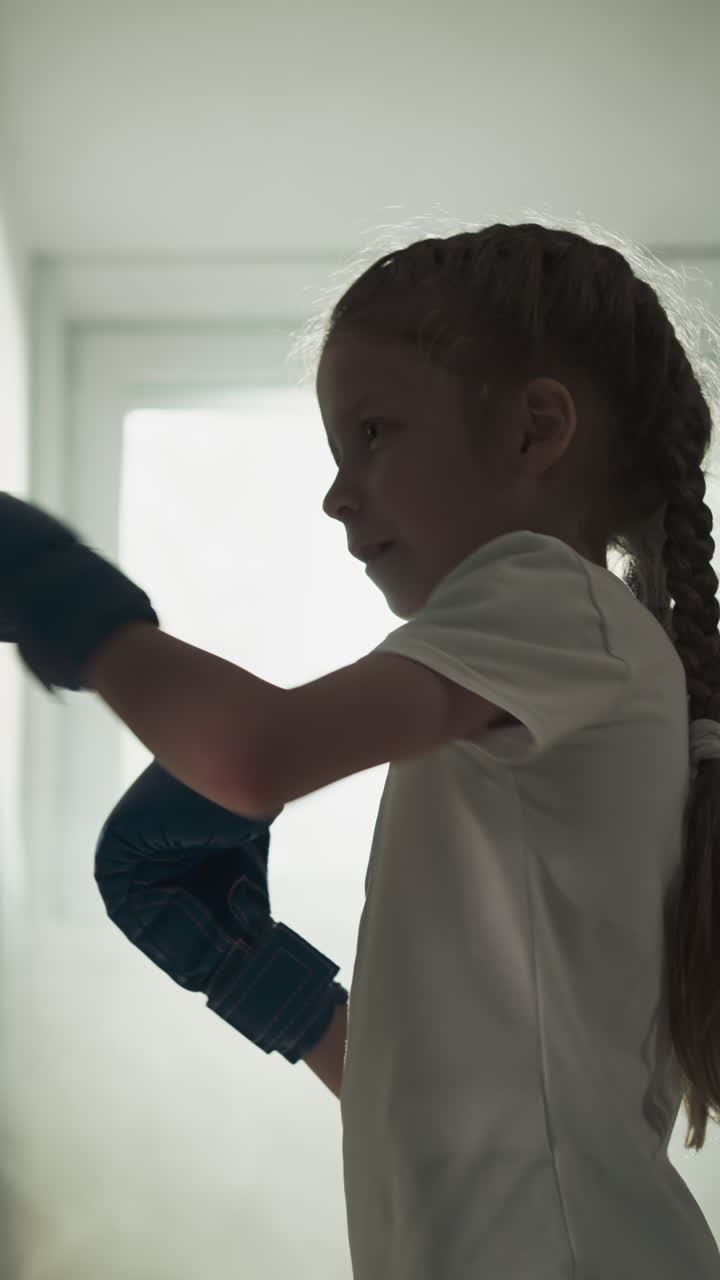 maestro y niño luchando en amistosos en el gimnasio. entrenador profesional utiliza almohadillas para las manos para ejercitar a la niña en el club deportivo en cámara lenta. lección de combate