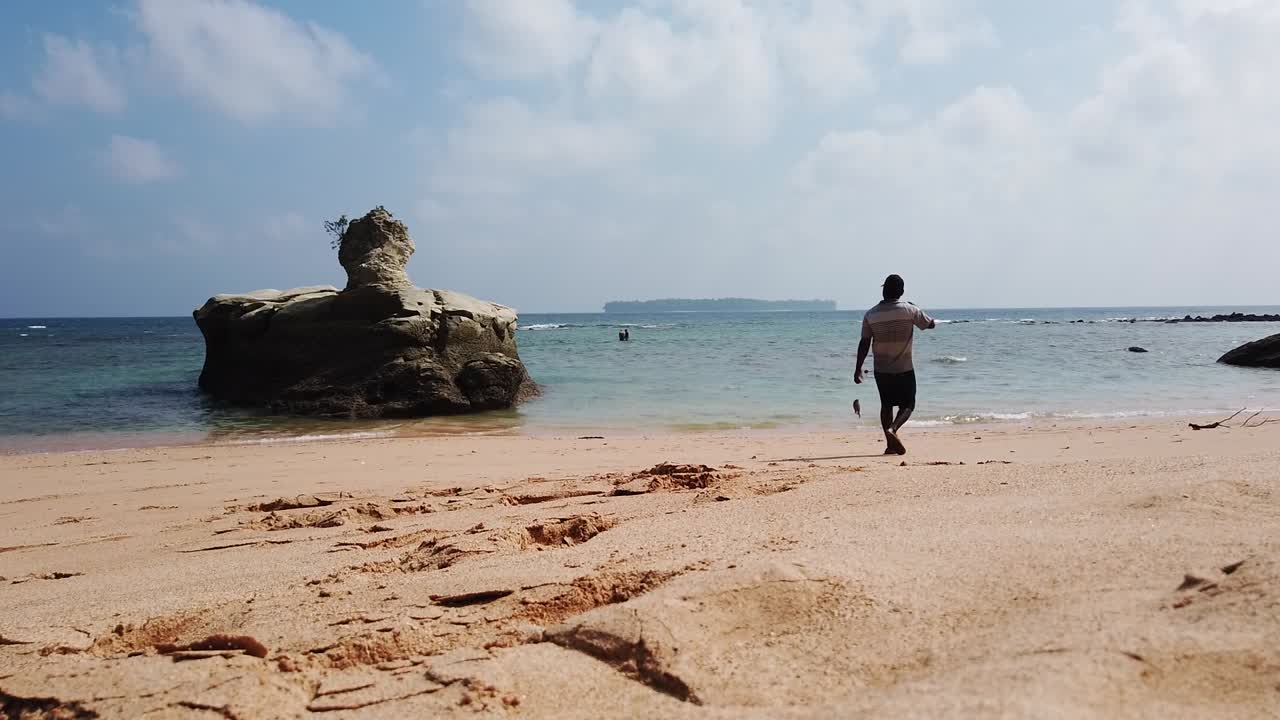 los pescadores en el agua son observados por un pescador con su captura de peces pequeños de los arrecifes alrededor de la remota isla de andaman