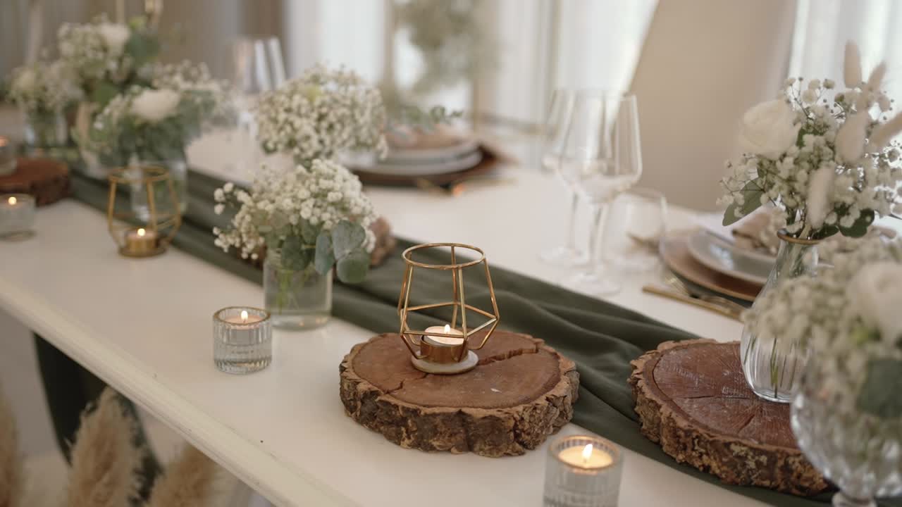 Wedding table decorated with candles, flowers, and wooden accents in rustic style
