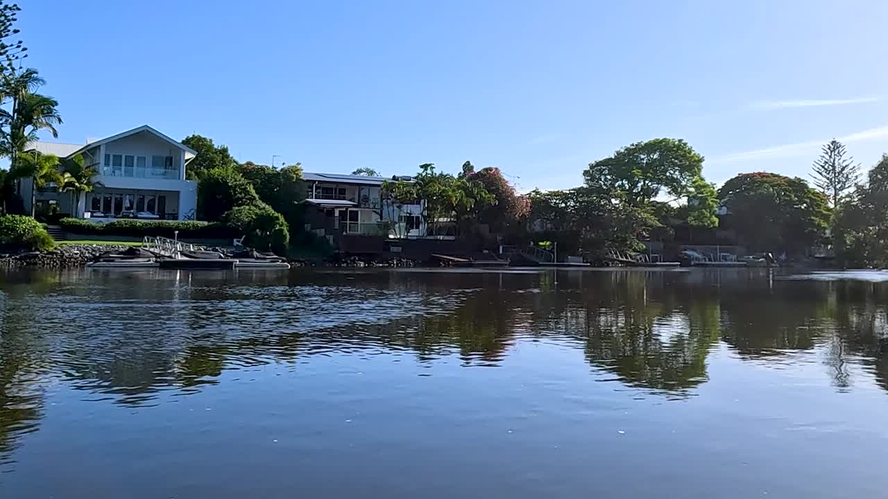 Explore tranquil waterfront scenes featuring elegant homes and lush greenery along the canal.