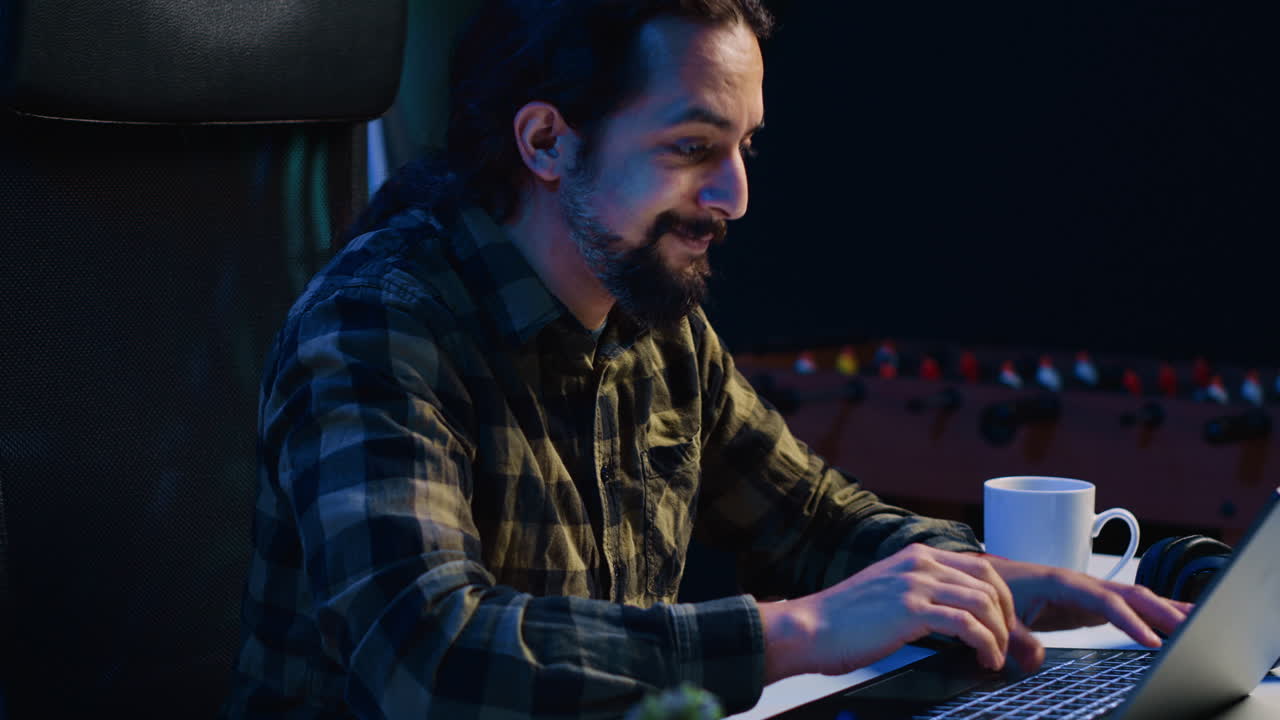 Cheerful man doing online shopping, typing credit card information on laptop