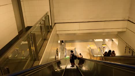 gente usando escaleras mecánicas en la estación de tren de bangkok