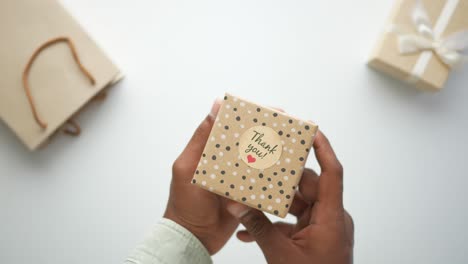 hands holding a thank you gift box