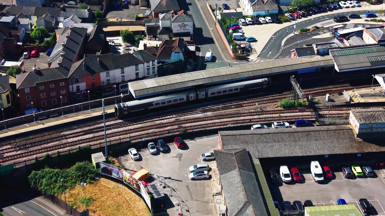 Luftfoto af et passagertog ved perroner på Salisbury banegård med flere jernbanespor og omkringliggende bybygninger