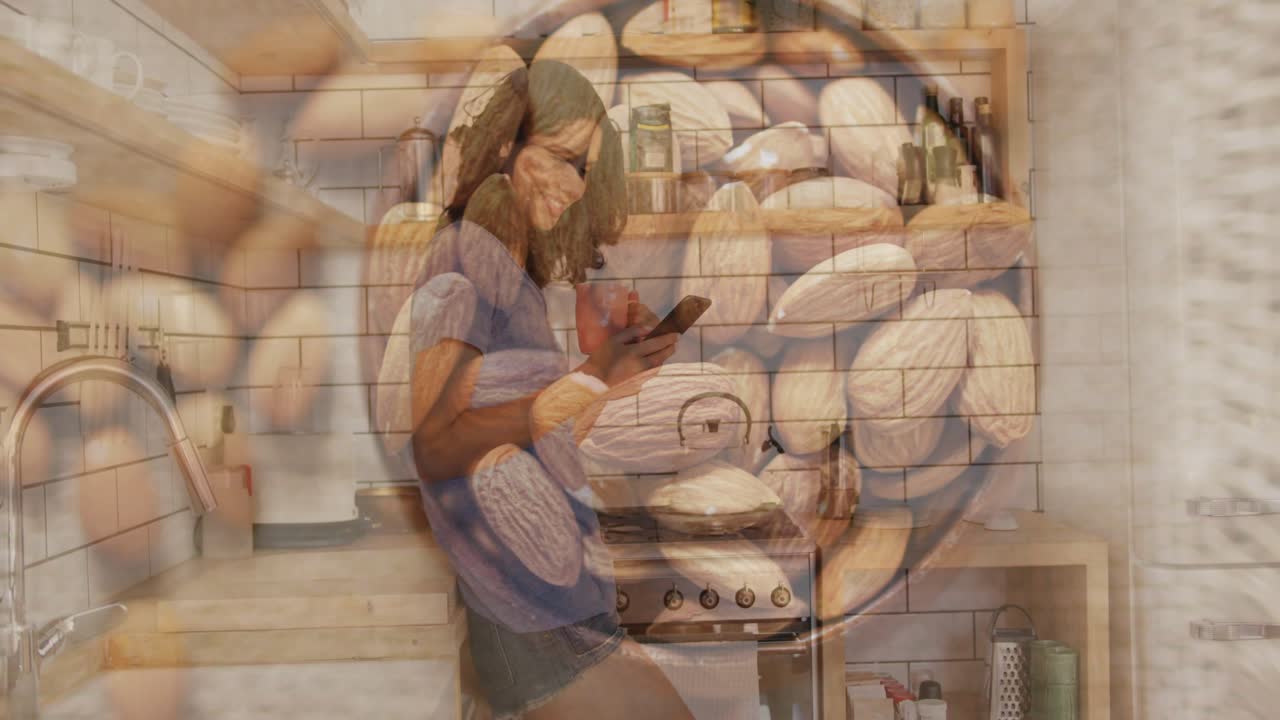 Woman in kitchen scrolling smartphone exploring snack causing transparent nuts overlay pulsing