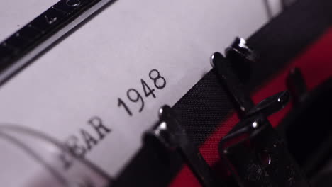 year 1948, typing on white paper in vintage typewriter, macro close up