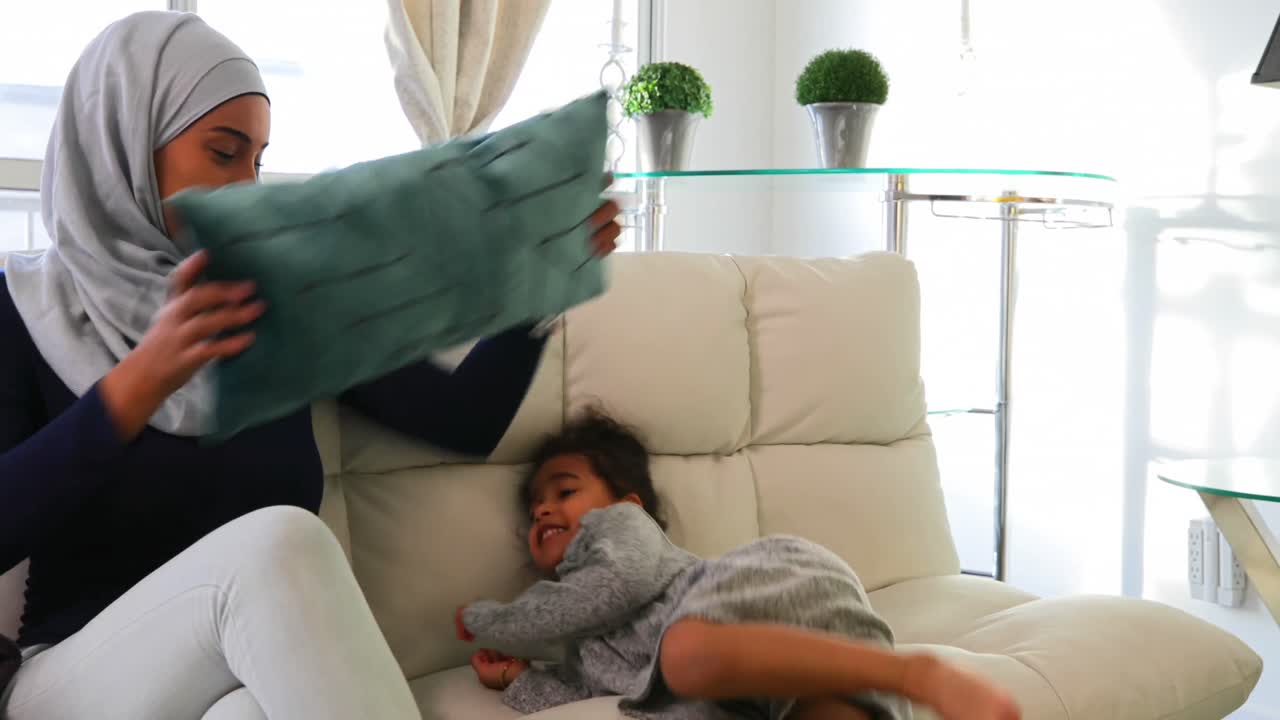 Young mother playing with her daughter in the living room 4k