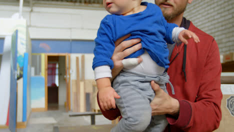 hombre sosteniendo a su hijo en el taller 4k