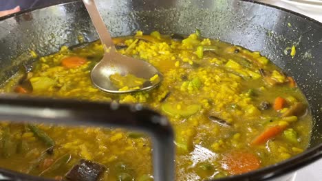 spanish soup rice paella with vegetables in slow motion