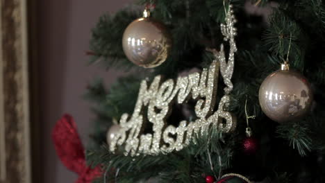 Footage-of-Christmas-decorations,-a-glittery-merry-Christmas-sign-on-a-Christmas-tree