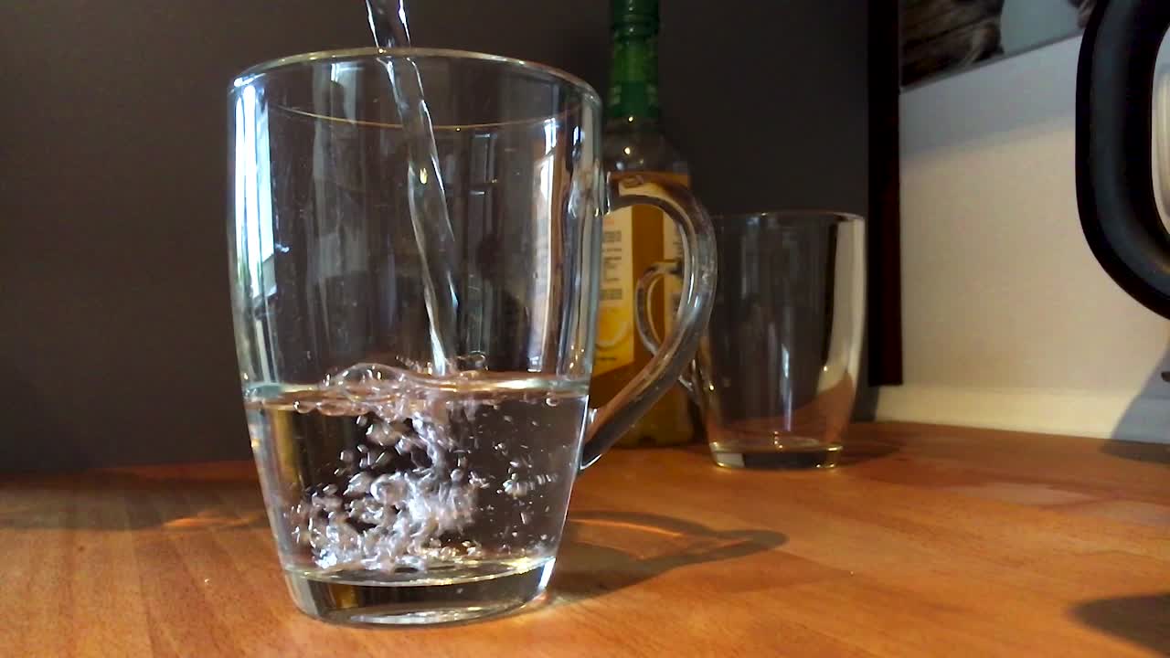 Pouring down water to a cup.