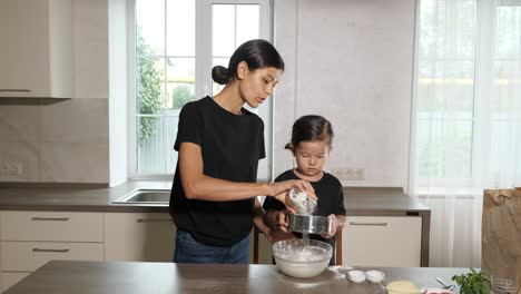 mother and daughter wearing black shirts and same hairstyle