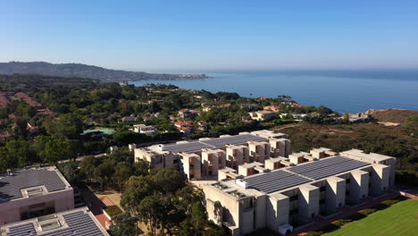 drone ascending next to salk institute in la jolla california with trees and ocean in the background - aerial