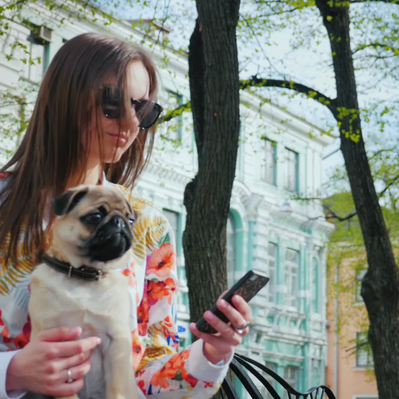 개를 데리고 있는 여자가 공원 벤치에 앉아 있다