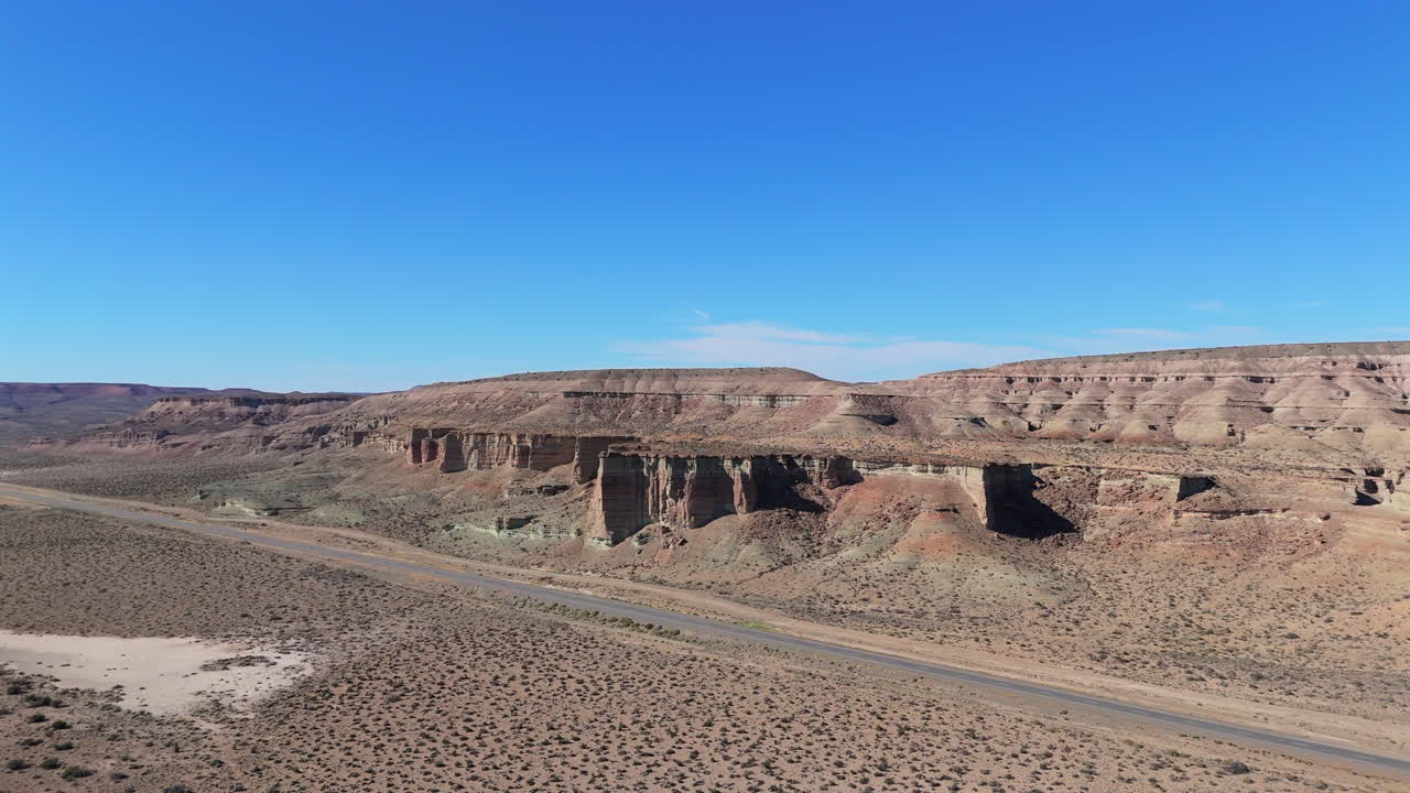 Wide aerial view of the Chubut hills, stunning pattern mountains with a sunny blue sky, landscape, copy space, dolly shot backwards