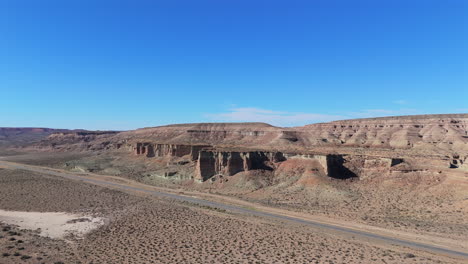 wide aerial view of the chubut hills, stunning pattern mountains with a sunny blue sky, landscape, copy space, dolly shot backwards
