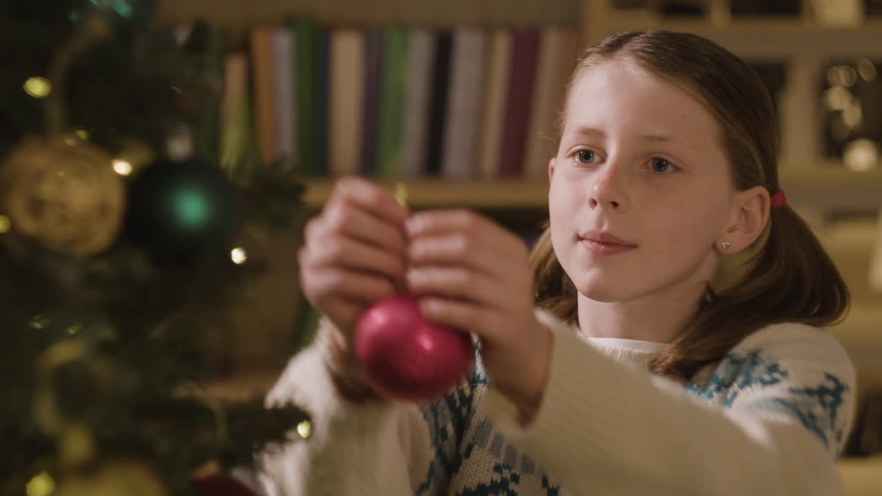 niña decorando el árbol de navidad
