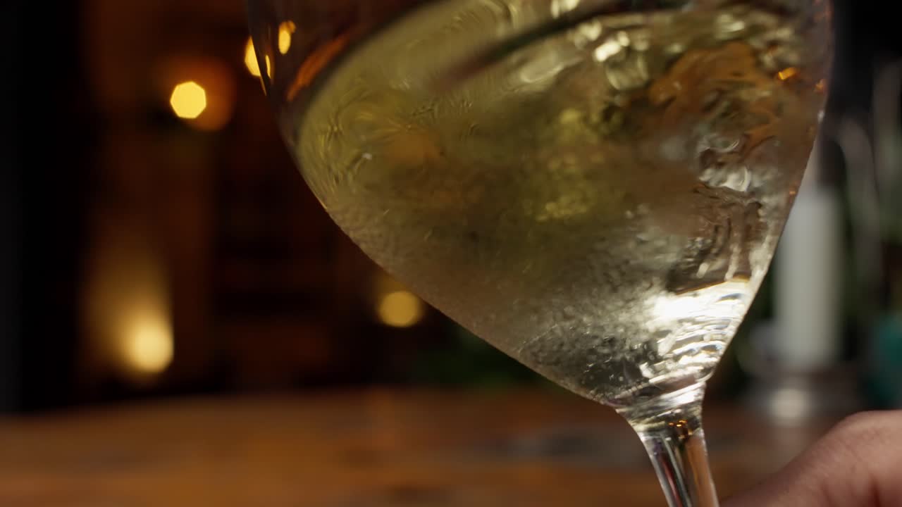 Primo piano al rallentatore di vino bianco messicano che volteggia con grazia all'interno di un calice da vino