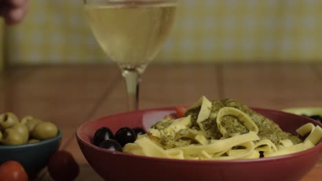 eating lunch of pasta with white wine close up shot