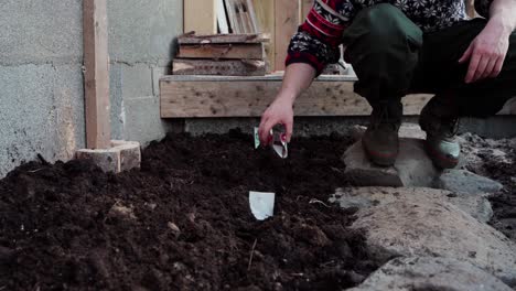 Man-Pouring-Seeds-Into-Fertile-Soil-Outdoors---Close-Up