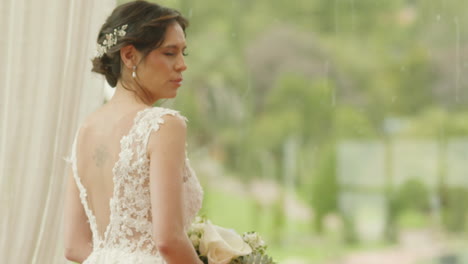 medium shot of a bride walking with a bouquet of flowers, wearing a lace dress as she heads to the ceremony.