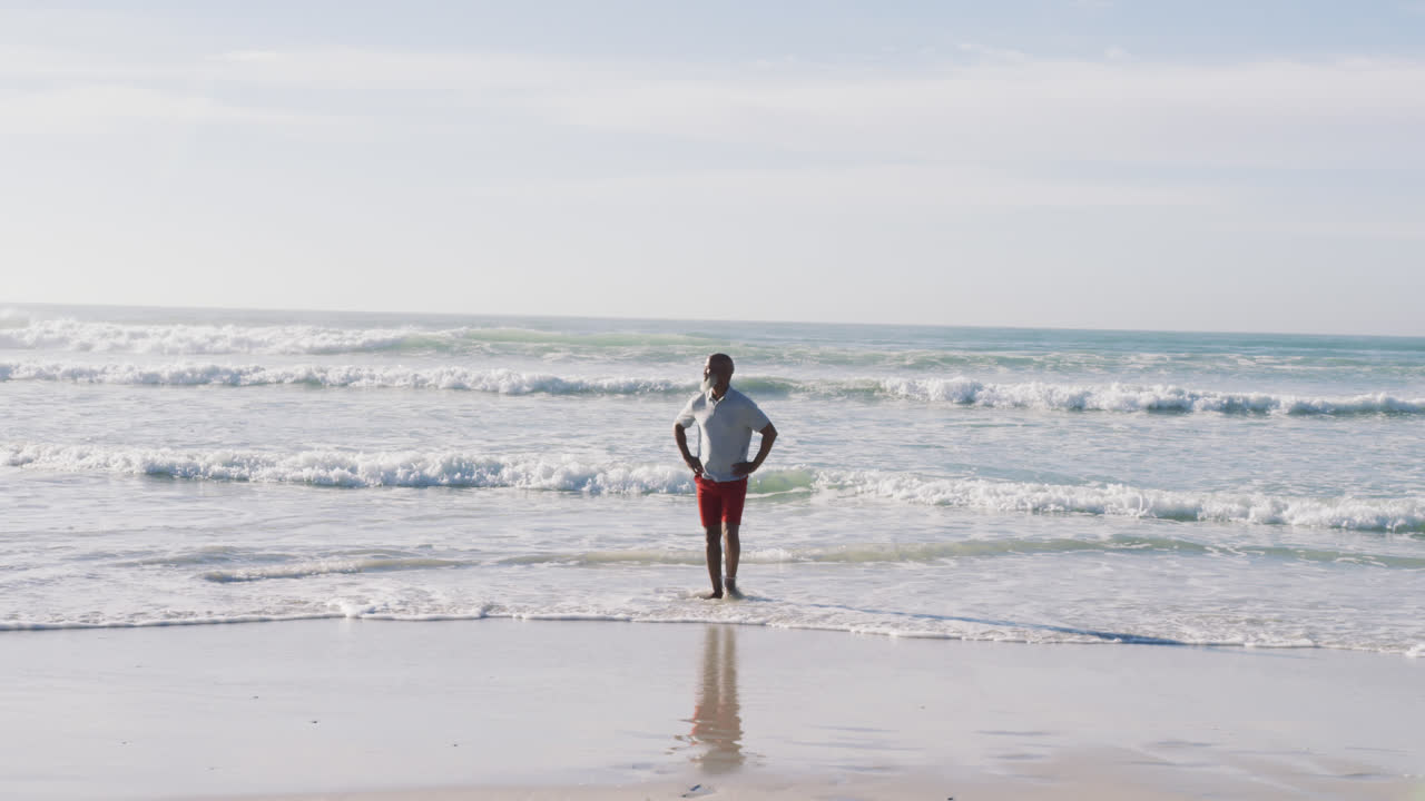노인 아프리카계 미국인 남자가 해변에서 고 미소 짓고 있습니다.