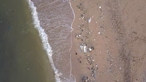 tropical beach in rayong, thailand with waste materials littering on the sand