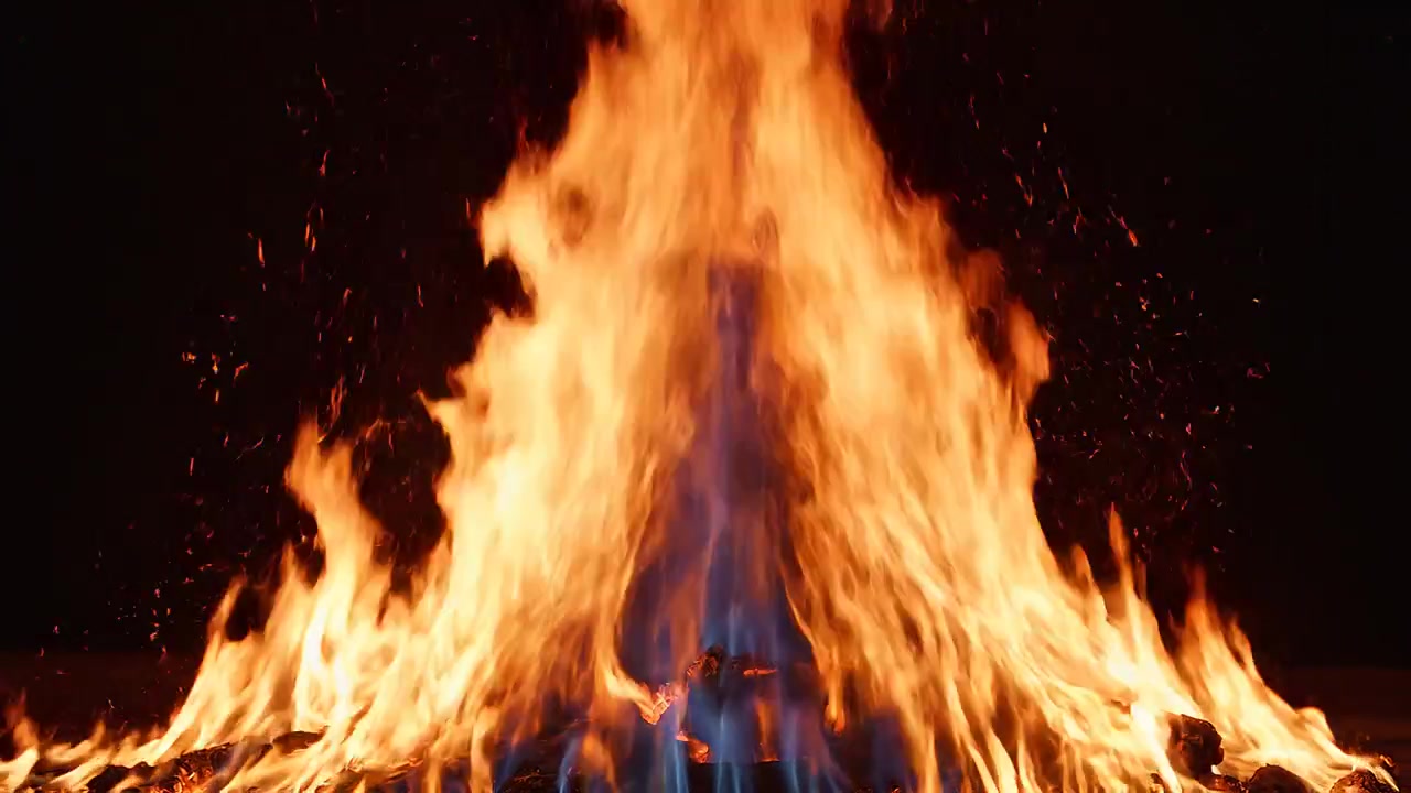 Intensiva brinnande brasflammor mot en mörk svart bakgrund