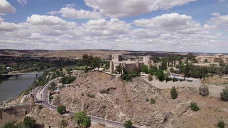 Castillo-De-San-Servando,-Toledo:-Majestätische-Burg-Am-Ufer-Des-Flusses-Tejo-–-Luftaufnahme