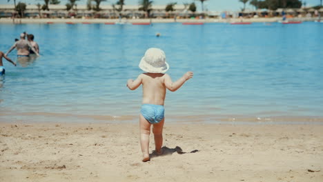 Kleiner-Junge-Genießt-Warmes-Wasser-Am-Meer.-Süßes-Kind,-Das-Am-Sandstrand-Läuft.