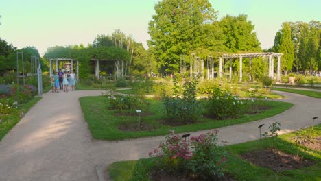 families stroll through the serene gardens of the park of the golden head, exploring lush greenery and playful paths in a sunlit afternoon setting.