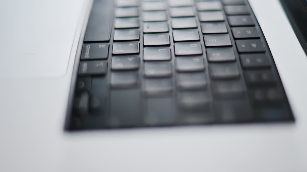 Close up of a black keyboard on a laptop with the light reflecting on it