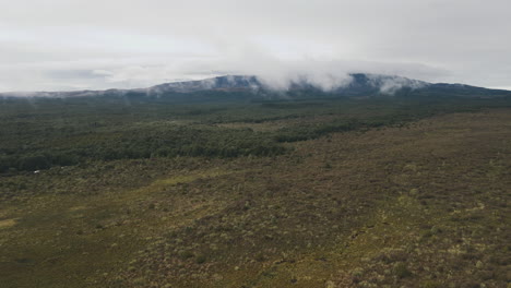 aerial view of a mountainous valley with forest and clouds