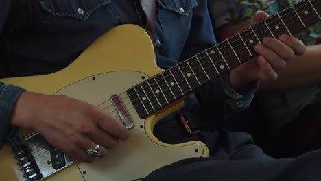 man plays vintage cream colored fender telecaster guitar, close-up