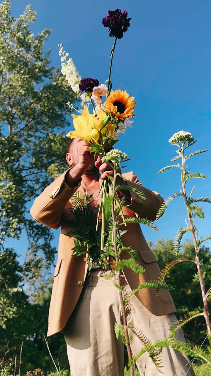 hombre sosteniendo un ramo de flores en un campo