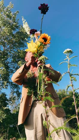 man holding a bouquet of flowers in a field