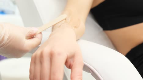 waxing procedure on a woman's arm