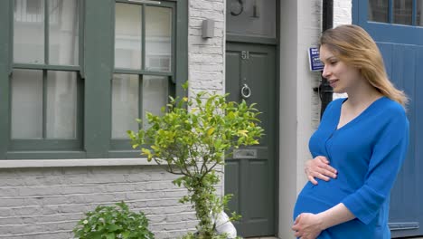 Happy-pregnant-caucasian-woman-walking-down-street-in-London