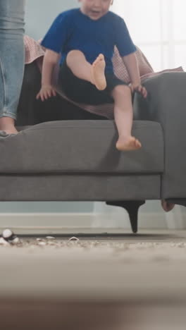 little boy gets down from sofa jumping amazed by coins amount with family in living room closeup slow motion. breaking piggy bank to output money