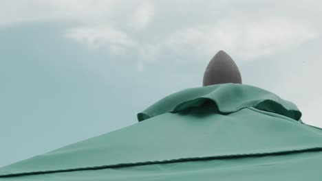 Umbrella-top-flowing-in-the-wind-with-clouds-in-the-sky