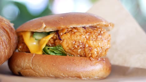 close-up of a delicious crispy chicken sandwich with sesame seeds, lettuce, and cheese