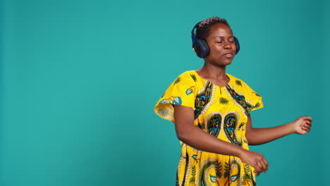 young adult having fun dancing and listening to her music in studio