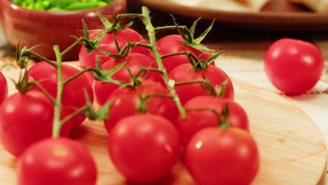 fresh cherry tomatoes and herbs on a wooden board