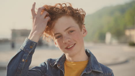 red haired teenager with freckles looks directly into the camera 1