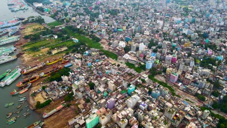aerial view of dhaka city, bangladesh at riverbank with dockyard. drone flying establishing shot