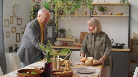 senior couple setting dinner table together